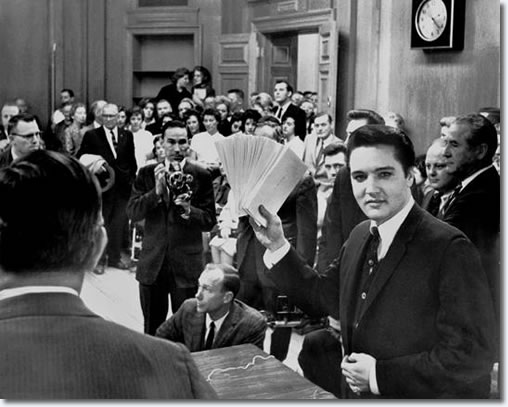 More than 150 people jammed into the mayor's office Tuesday December 17, 1963 to see Elvis Presley hand out Christmas checks totaling $55,000.