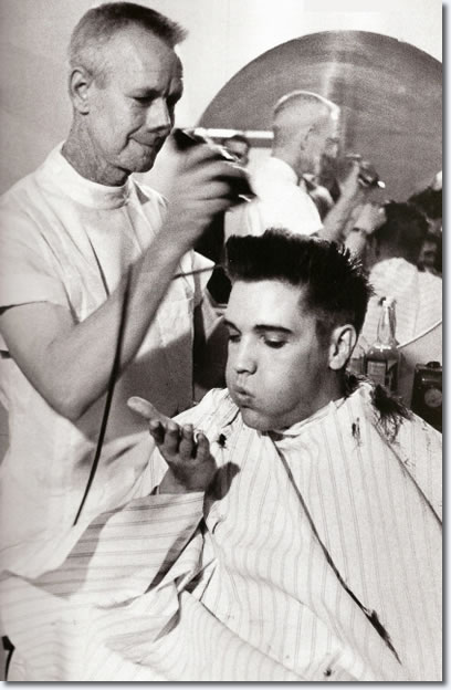 Elvis Presley blows a strand of hair from his hand, while receiving a haircut from a US Army barber, Fort Chaffee, Arkansas.