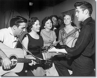 Faron Young and Elvis entertain fans backstage while Jane Giles, Elsie Medlin, Bob Montgomery and Valerie Harms look on