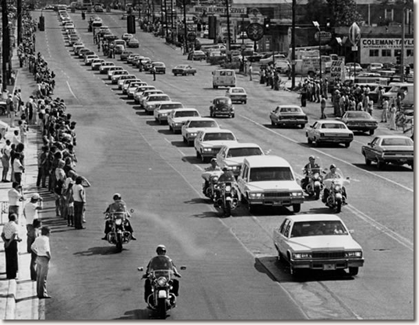 A string of white Cadillacs follow the hearse carrying the body of rock 'n' roll musician Elvis Presley along Elvis Presley Boulevard on the way to Forest Hills Cemetery in Memphis, Tenn., Aug. 19, 1977. 